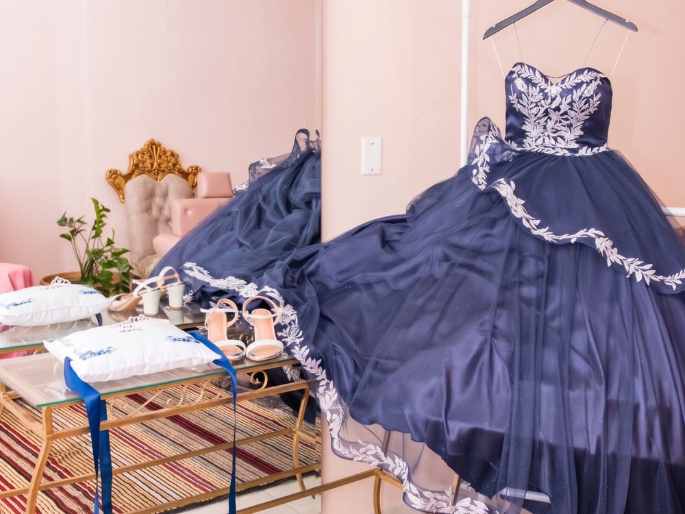 Quarto rosa com vestido de debutante na arara, espelho e sapatos